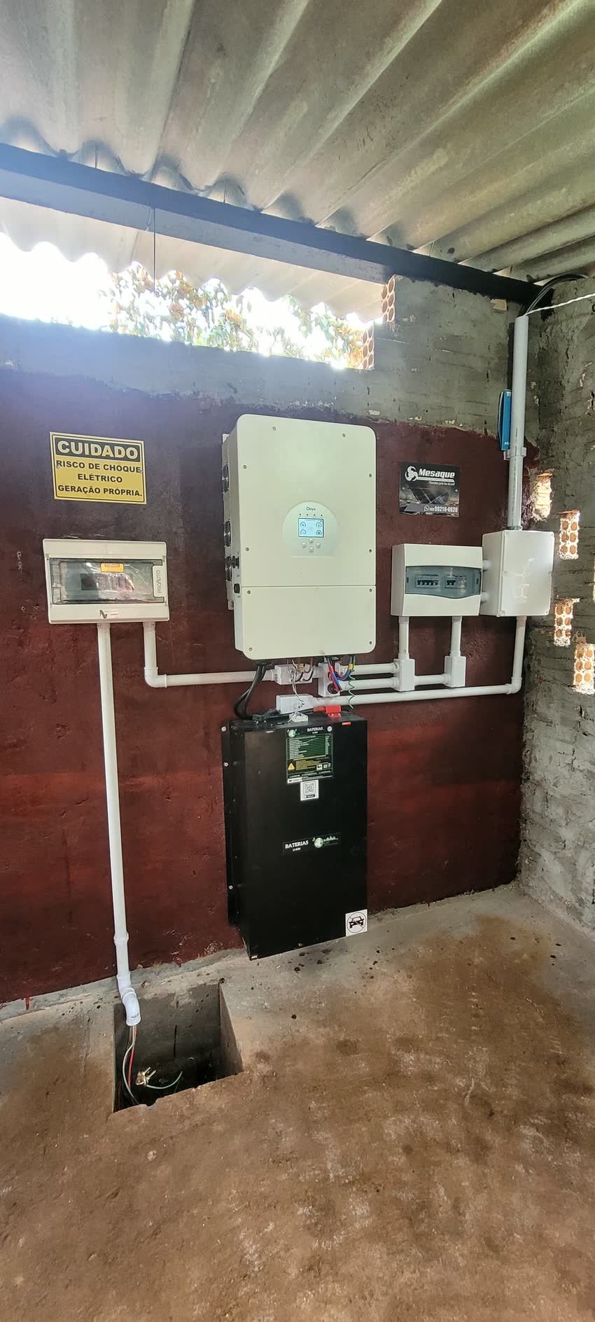 Inversor e quadro de proteção instalados em parede de alvenaria aparente
