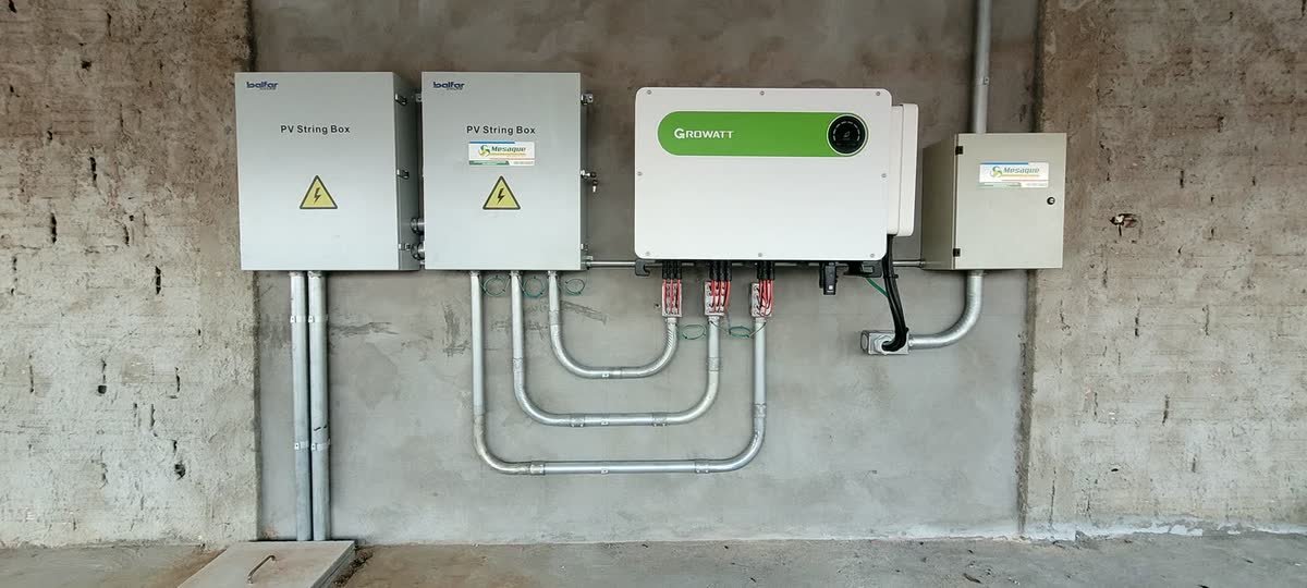 Duas string box de proteção CC, inversor Growatt e quadro geral em galpão