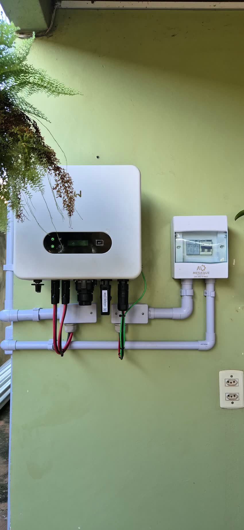 Inversor e medidor em parede externa, com eletroduto descendo até o quadro